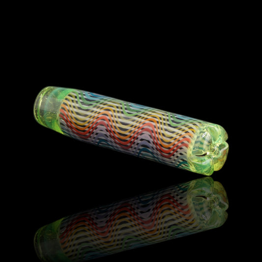 Angled view of the Leisure Glass Citrus Prism glass tip showing rainbow Hypnotech waves and transparent yellow-green ends with fine shimmering specks