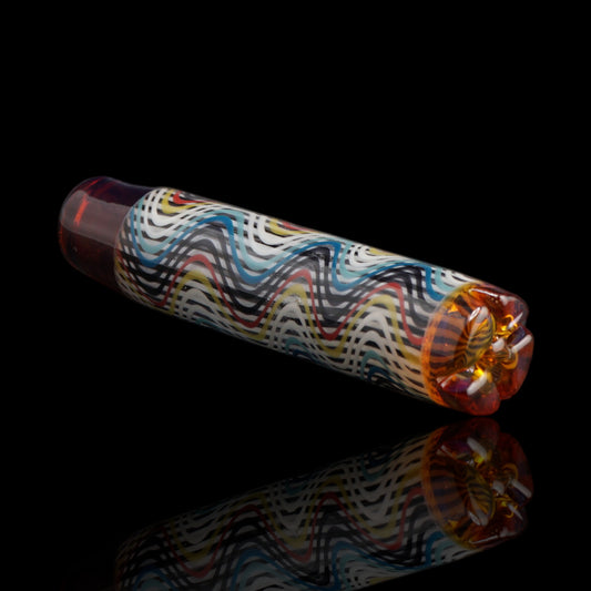 Angled view of the Leisure Glass Sienna Drift glass tip showing its multicolored Hypnotech wave pattern and reddish-brown ends with amber highlights