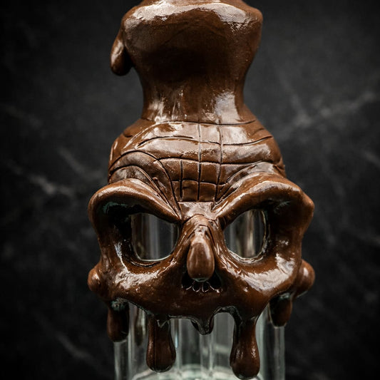 Detailansicht eines schmelzenden Schädelmotivs an einem Glas Dab Rig im Studio