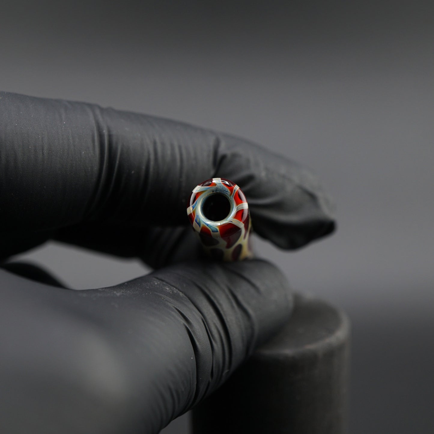 SteveHGlass Crimson Vein 9.7 mm glass tip held in hand showing the interior structure and deep red cream glass design.