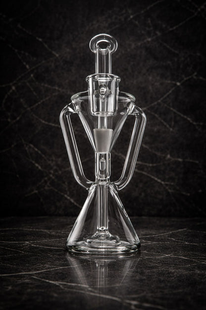 Clear glass recycler dab rig shown from the front in a dark studio environment