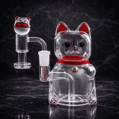 Maneki-Neko Dab Rig aus Glas mit roten Akzenten vor dunklem Hintergrund