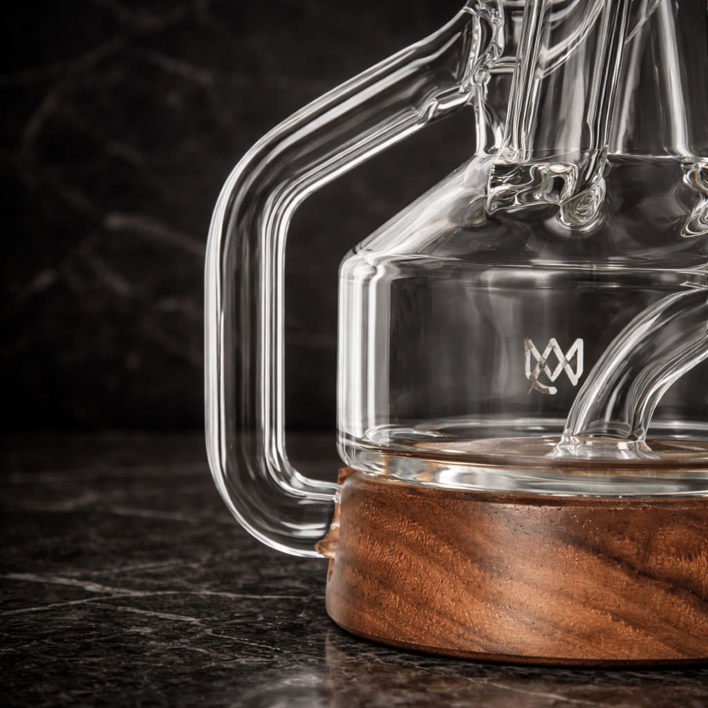 Detail view of a clear glass recycler dab rig with wooden base and percolator