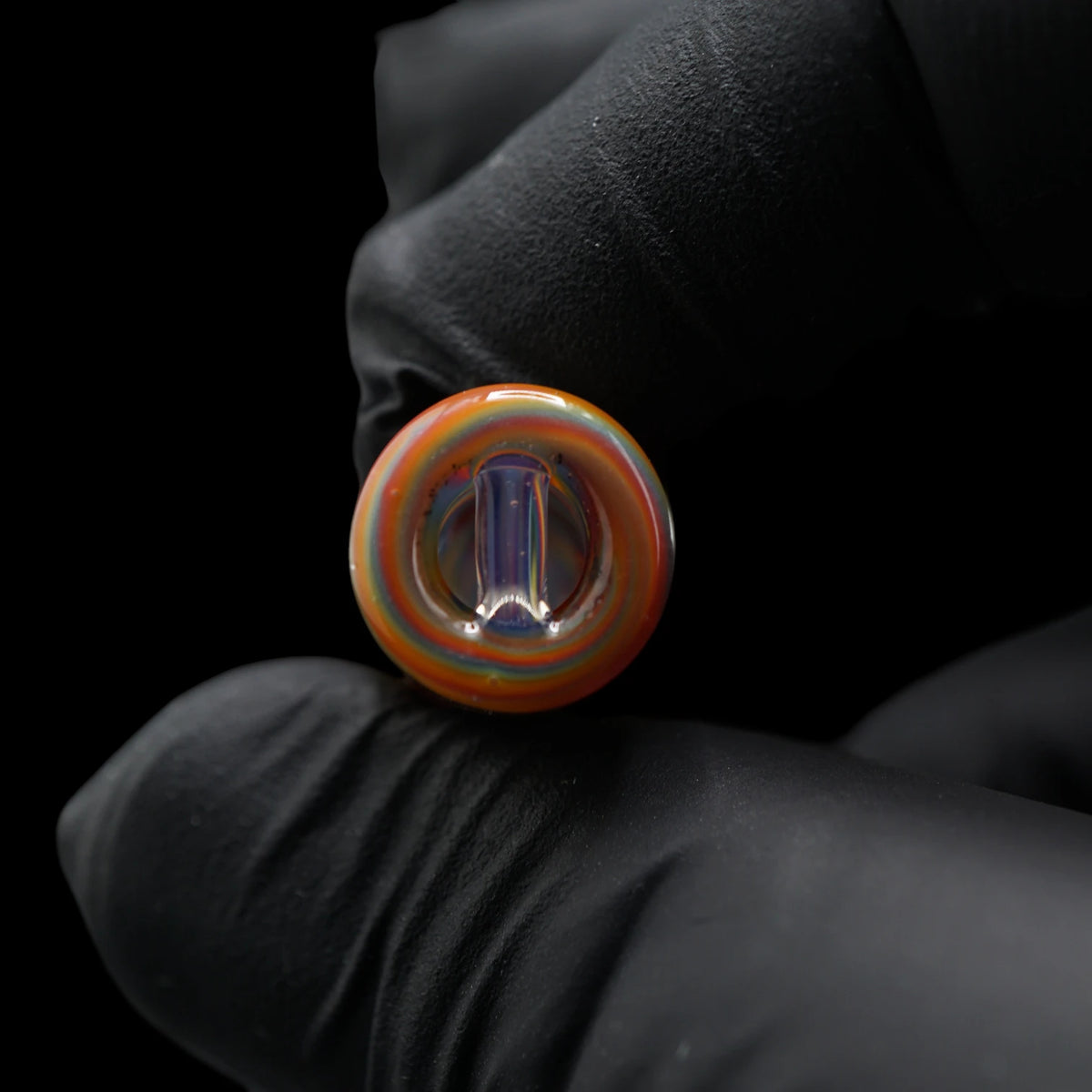Nahaufnahme des 2-Loch-Systems am Rainbow Rhythm Glastip mit transparentem Glassteg und mehrfarbigen Ringen