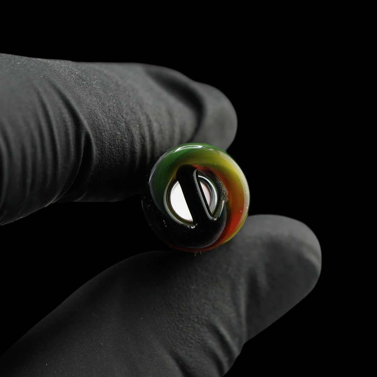 Nahaufnahme des Roots Flow Glastips mit schwarzem Glassteg im 2-Loch-System und rot-gelb-grün gestaltetem Rand