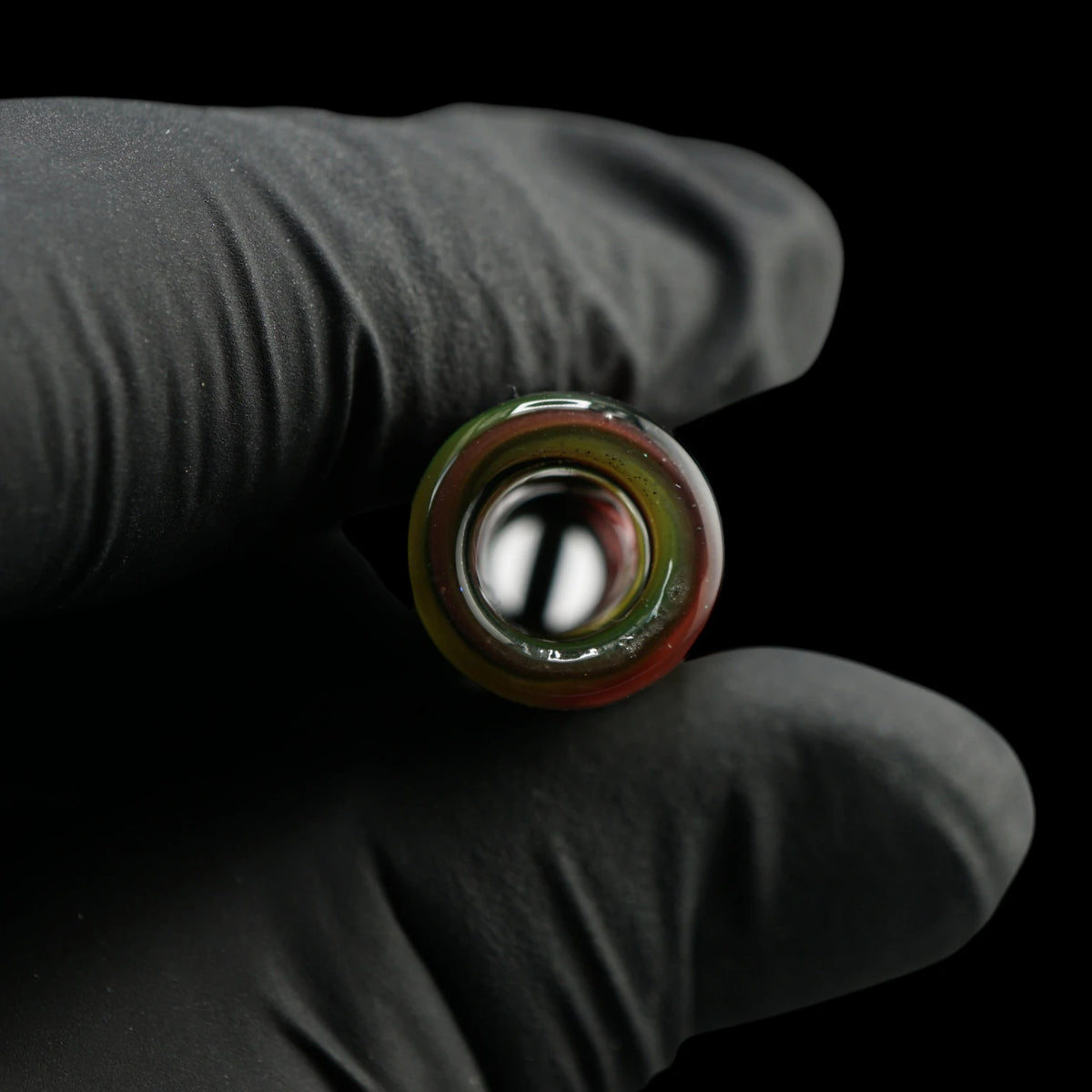 Blick durch die runde Öffnung des Jcreature Glass Roots Flow Glastips mit roten, gelben und grünen Farbringen am Rand