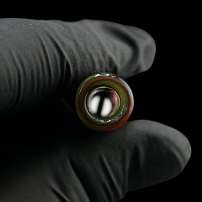 Blick durch die runde Öffnung des Jcreature Glass Roots Flow Glastips mit roten, gelben und grünen Farbringen am Rand