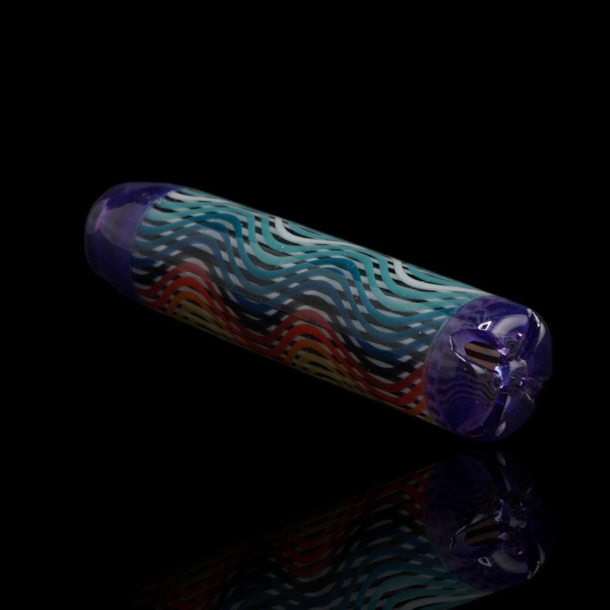 Angled view of the Leisure Glass Amethyst Flow glass tip showing turquoise and blue waves, warm color accents and a transparent purple filter end