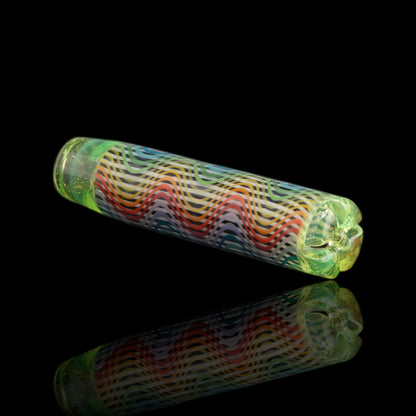 Angled view of the Leisure Glass Citrus Prism glass tip showing rainbow Hypnotech waves and transparent yellow-green ends with fine shimmering specks