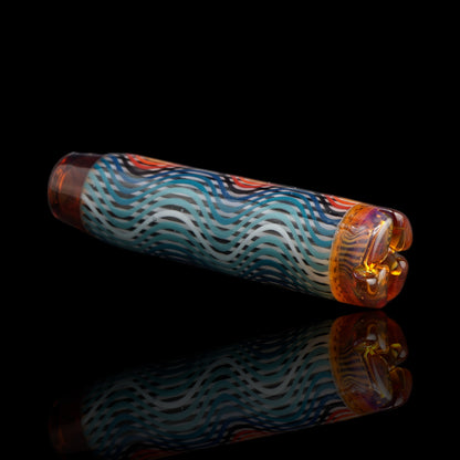 Angled view of the Leisure Glass Ember Wave glass tip showing turquoise, blue and white Hypnotech waves with a glowing orange filter end