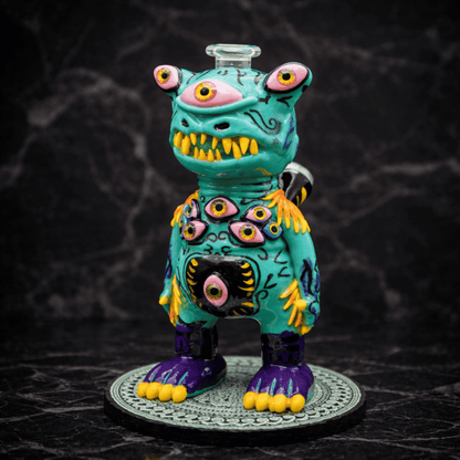 Handgefertigtes Monster Dab Rig aus Glas in Türkis mit mehreren Augen und gelben Zähnen in der Seitenansicht