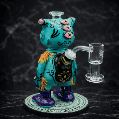 Seitenansicht eines handgefertigten Monster Dab Rigs aus Glas in Türkis mit Glasbanger und detailreicher Bemalung