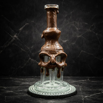 Skull Dab Rig aus Glas mit schmelzender brauner Oberfläche in dunkler Studioaufnahme