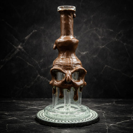 Skull Dab Rig aus Glas mit schmelzender brauner Oberfläche in dunkler Studioaufnahme