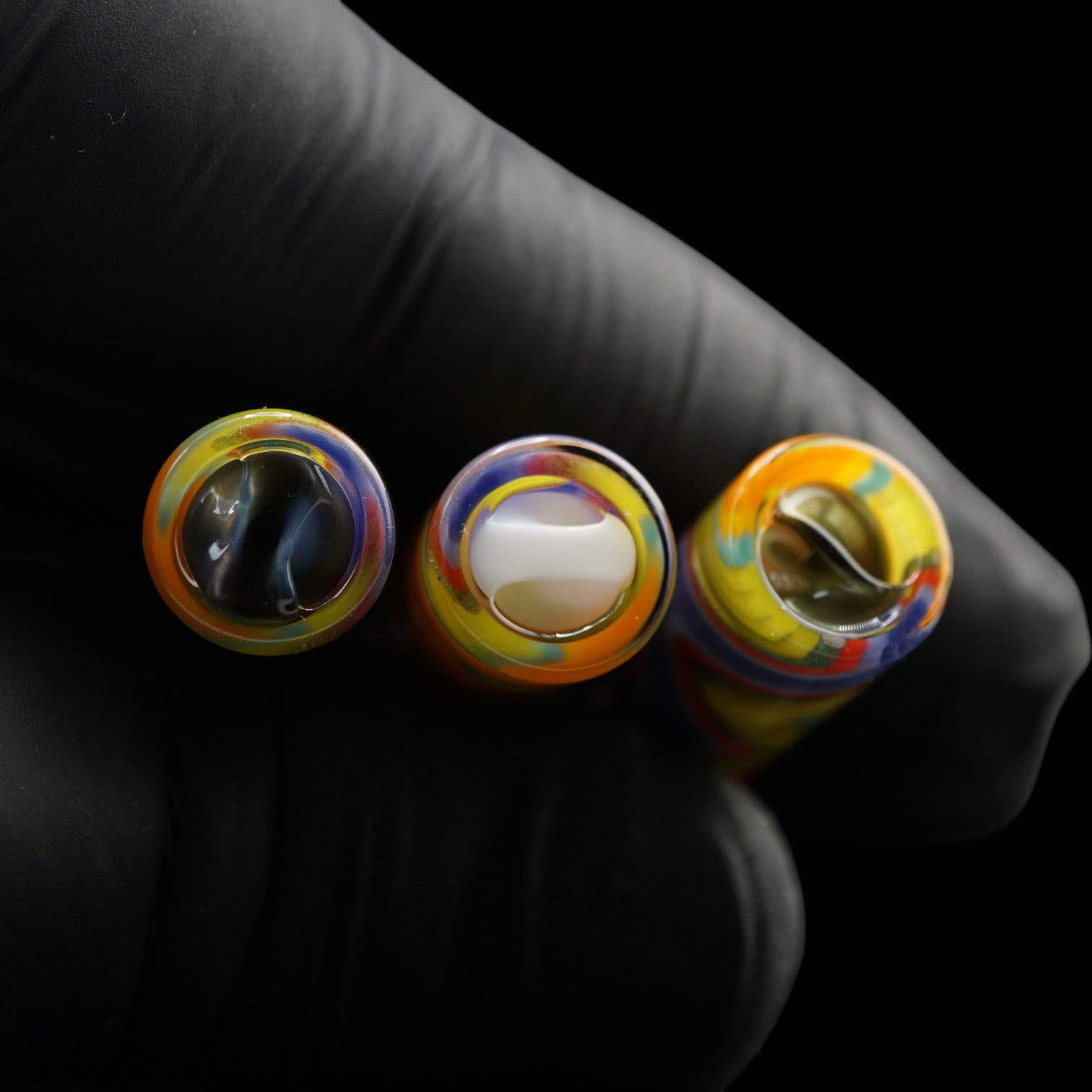 Top view of three Tyeglassarts Sunset Pulse glass tips with blue gold, white and gold Rotini filters